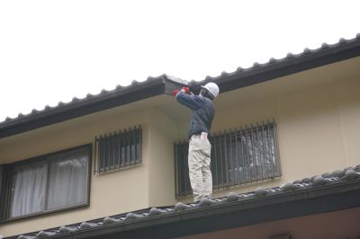 屋根点検の専門スタッフが瓦のズレや棟板金の状態を確認している様子