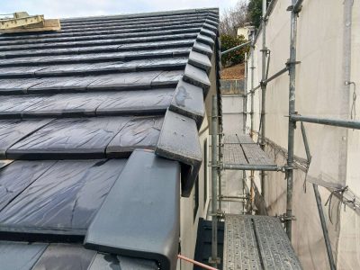 築29年の屋根袖瓦（ケラバ部分）の現状。手前の袖瓦が固定具の劣化により外側に浮き上がり、今にも落下しそうな危険な状態。