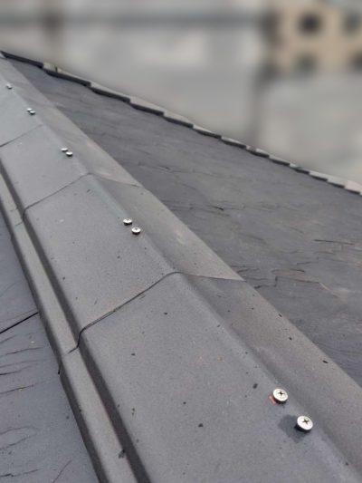 岐阜市K様邸の屋根修理完了後の棟瓦。新しい貫板と防水漆喰によって、棟が強固に再現されている。平板瓦「セラムF3」が一直線に並び、防災釘でしっかりと固定され、台風や地震にも耐えうる強さを備えている。