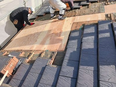 岐阜市K様邸の天窓撤去工事風景。天窓が取り除かれた開口部に、大工が新しい構造用合板（野地板）を隙間なく敷き詰め、屋根の下地を再構築している。