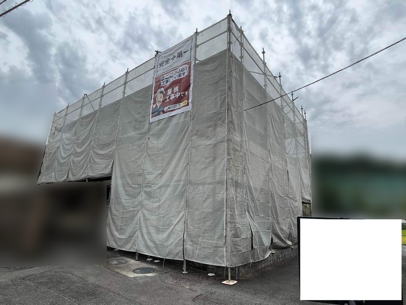 屋根カバー工事と外壁塗装のために設置された住宅の足場