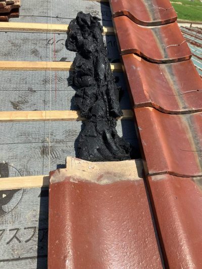 水糸を張り、既存瓦を丁寧に並べ直す作業風景