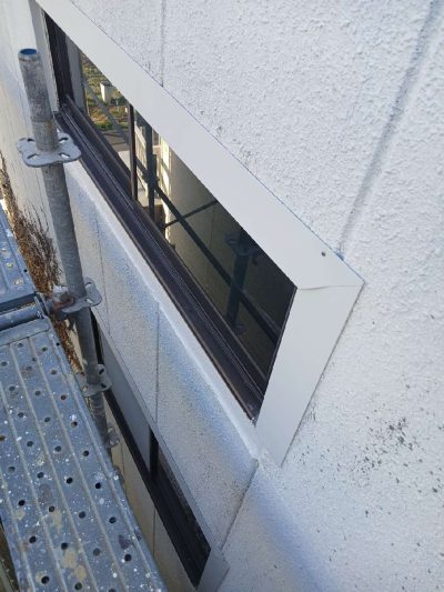 岐阜市H様邸の外壁・サッシ廻り雨漏り補修（施工中）。新設した木下地の上から白いガルバリウム鋼板で板金カバーを施し、コーキングで隙間を防水処理した窓サッシの様子